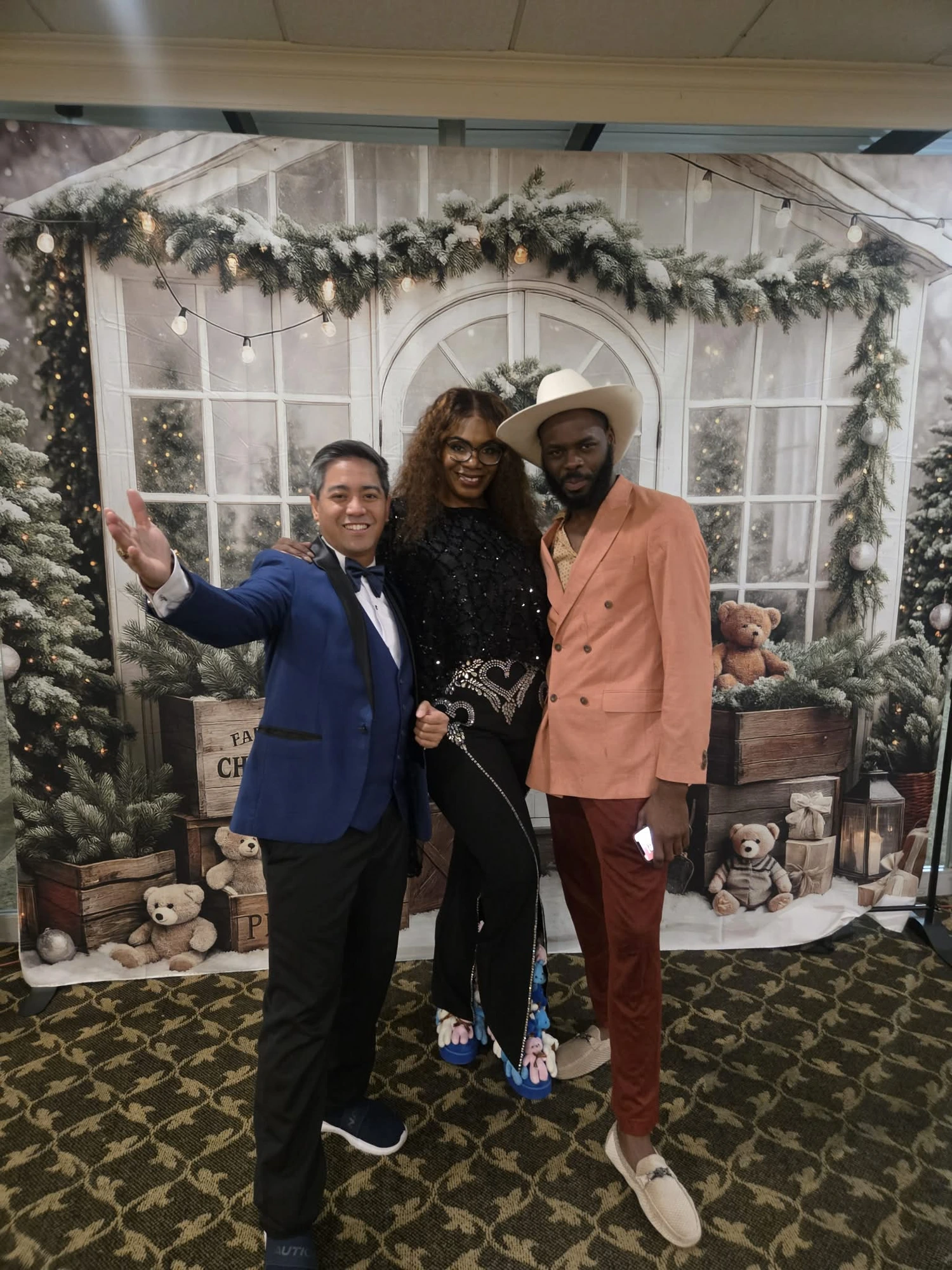 Three guests posing by the winter backdrop