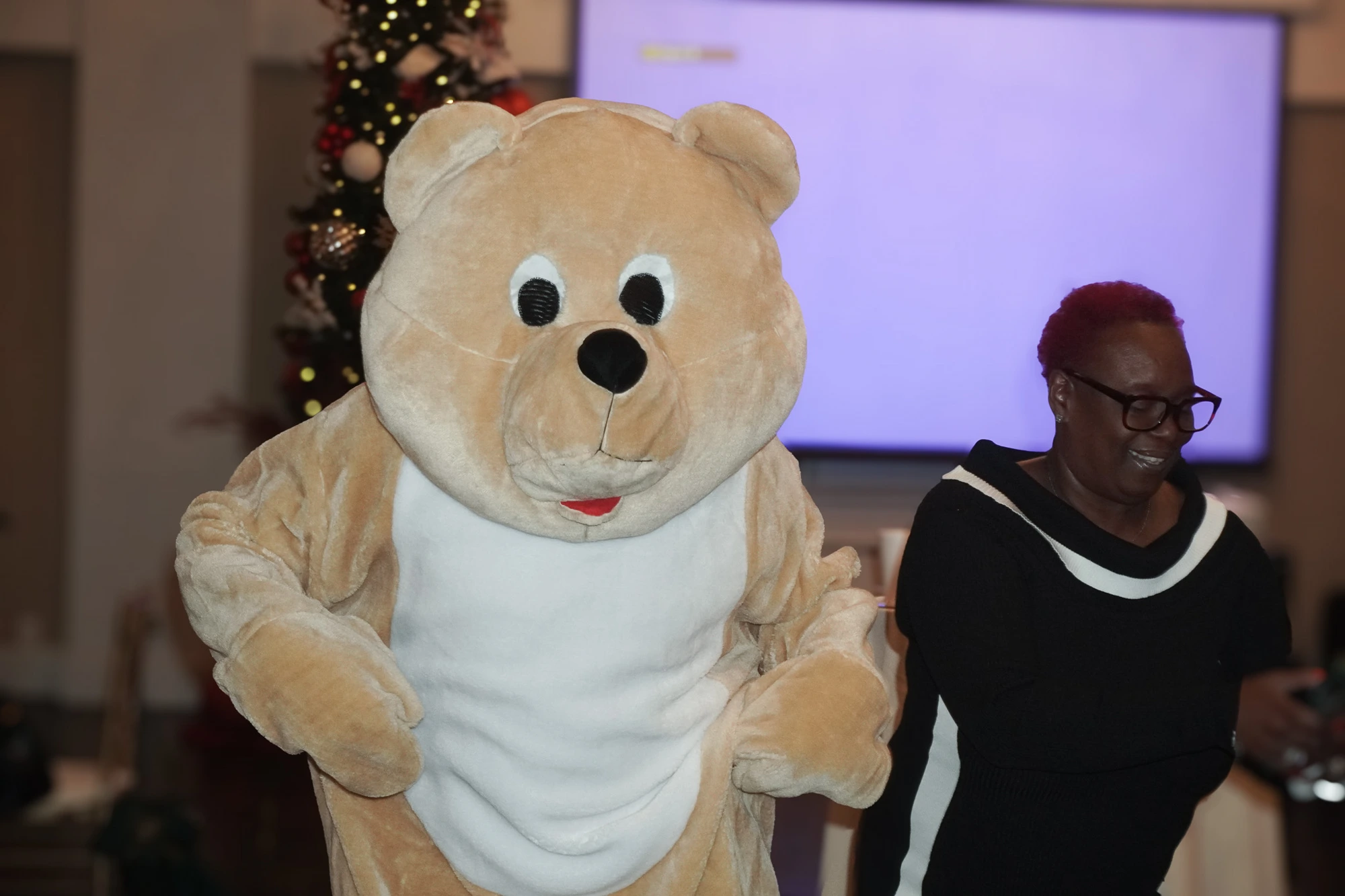 The kindness bear mascot posing with a guest