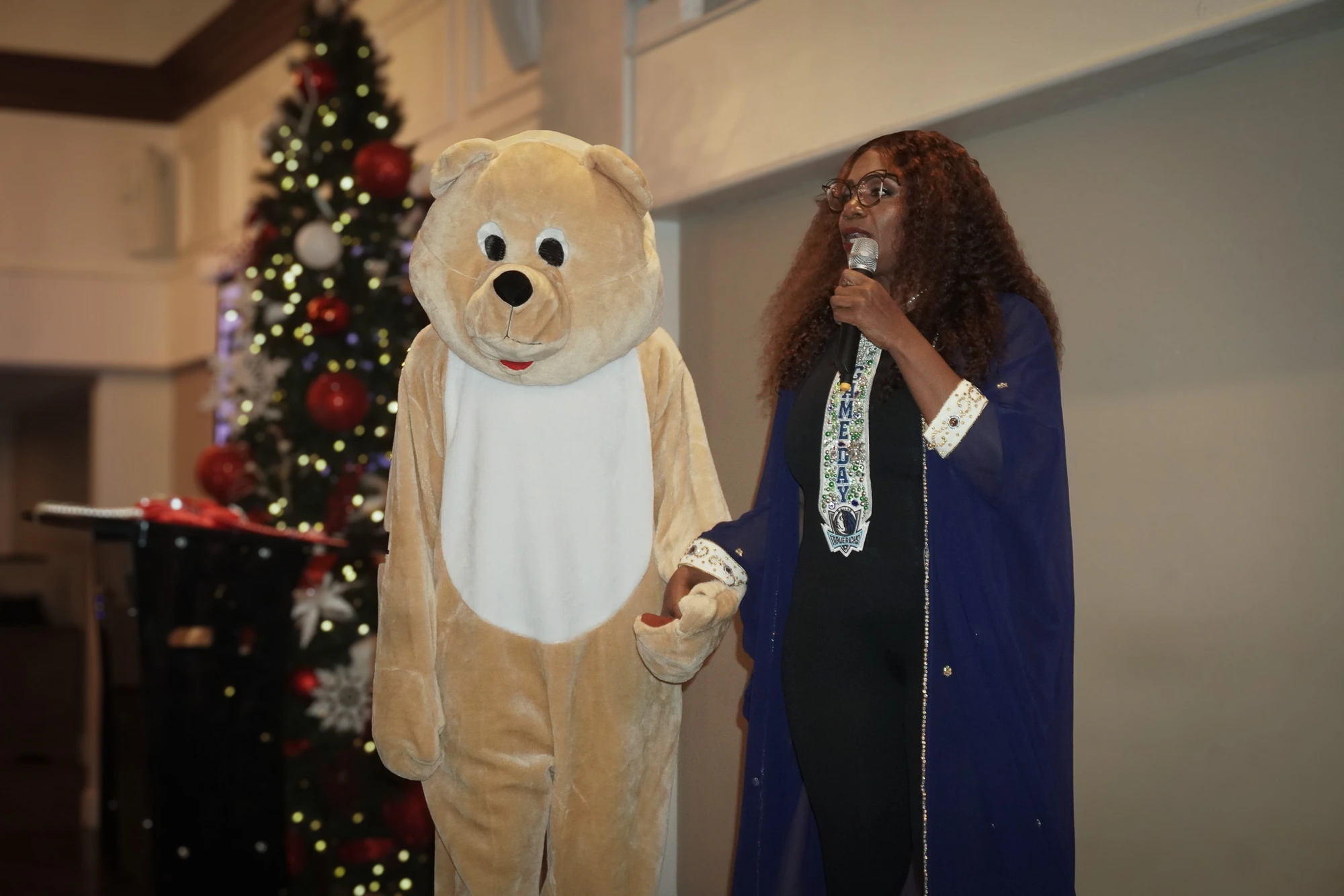 The kindness bear mascot on stage with the host