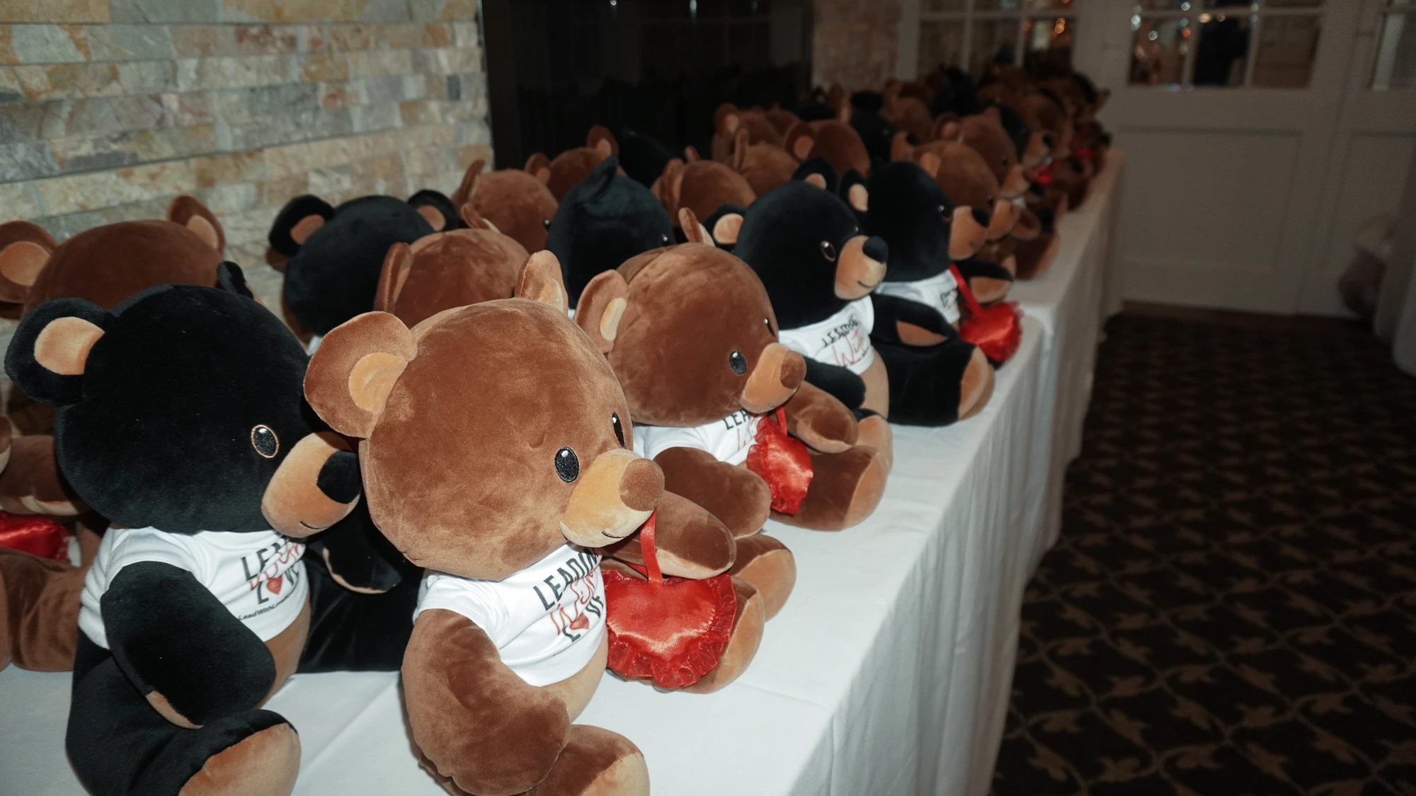 Rows of kindness bears in Leading with Love shirts awaiting adoption