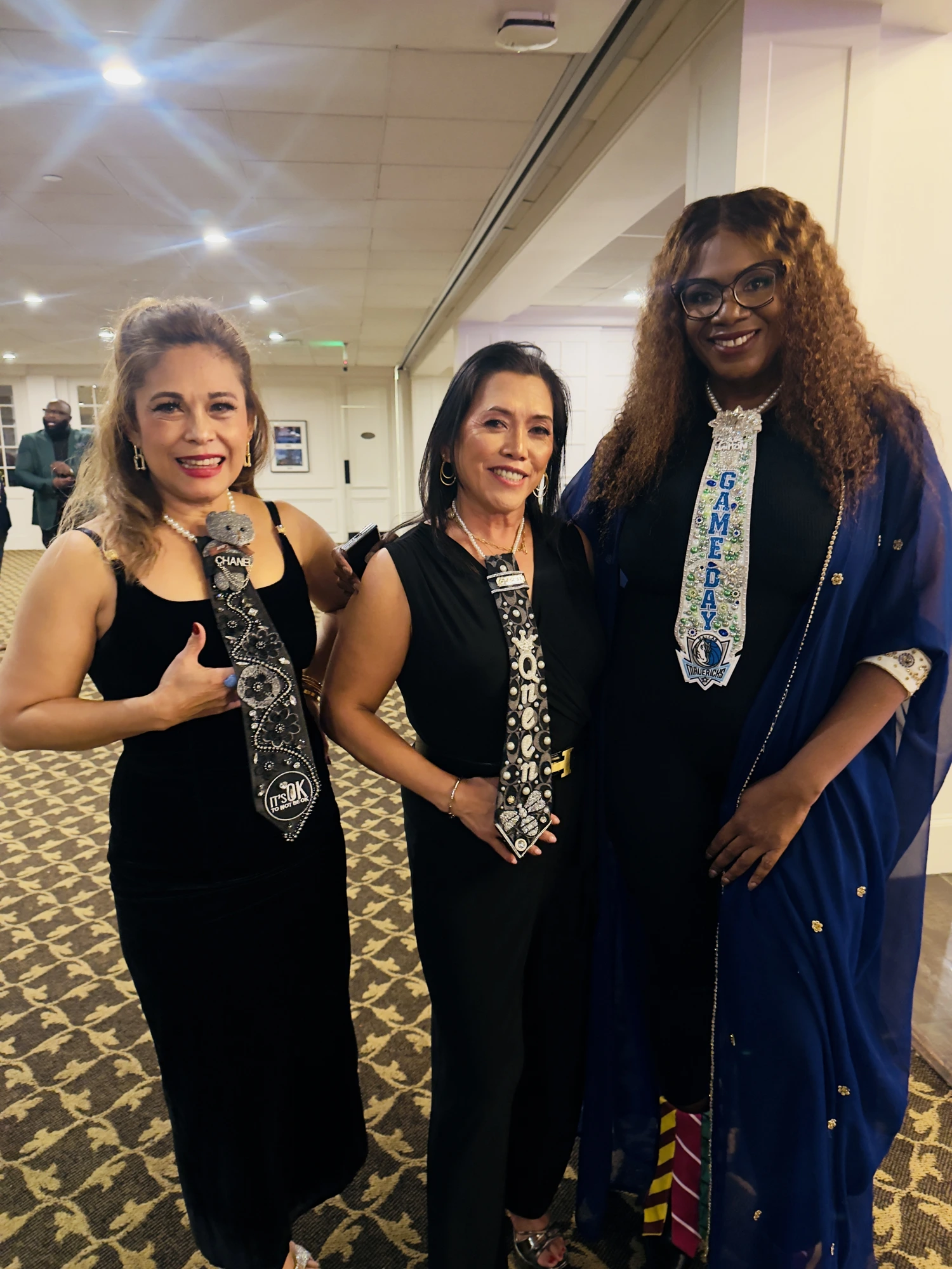 Three guests showing their decorated ties in the hallway