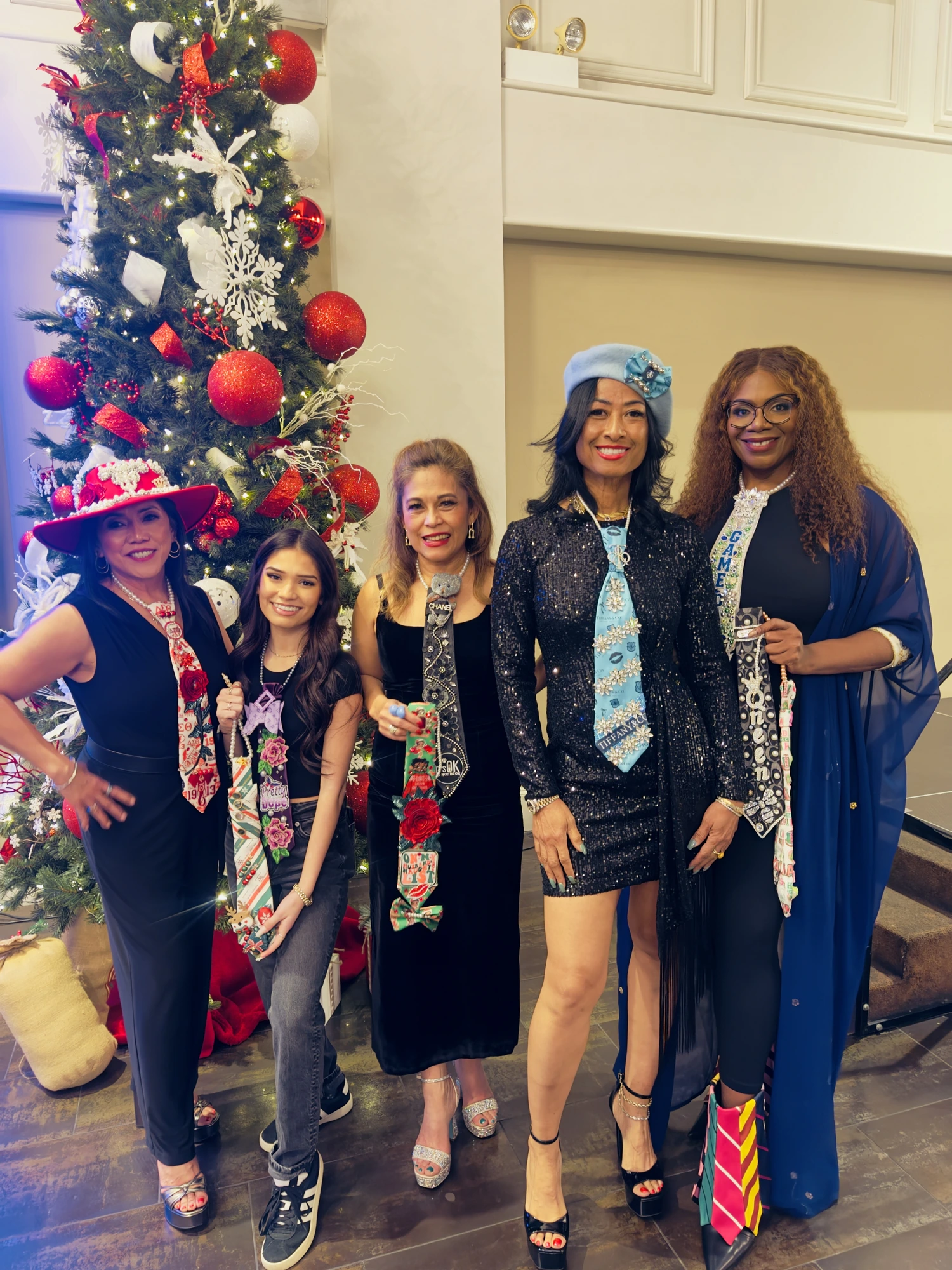 Five guests of all generations with decorated ties by the tree