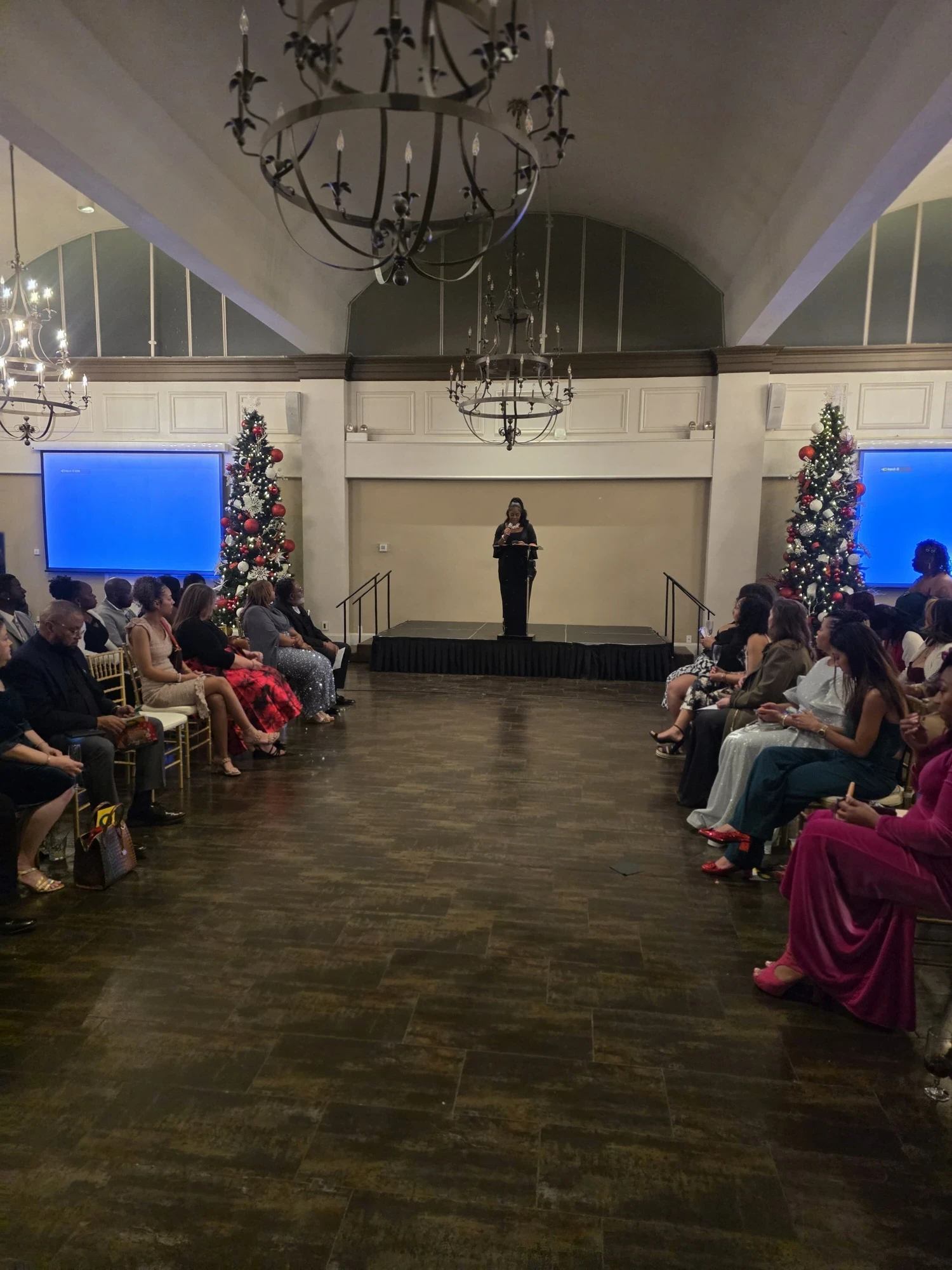 The audience awaiting the fashion show under chandeliers